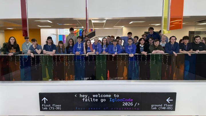 IglooCode event team gathered above the welcome sign in the venue atrium